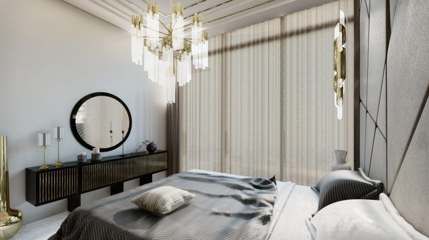 Une chambre moderne comprenant un grand lit avec une literie à rayures, un miroir rond au-dessus d'une console sombre et élégante, des suspensions élégantes et un éclairage naturel doux filtré à travers des rideaux transparents à Samana Waves Dubai.