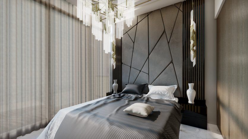 Chambre moderne du Samana Waves Dubai comprenant un grand lit avec une literie grise, une tête de lit à motifs géométriques et d'élégantes suspensions. La douce lumière du jour filtre à travers des rideaux transparents.