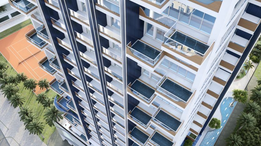 Vue aérienne de Samana Waves, un immeuble moderne de grande hauteur à Dubaï avec balcons privés et piscines, entouré de palmiers et d'un terrain de basket.