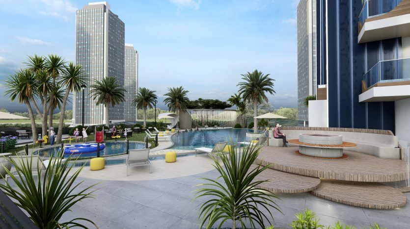 Luxueuse piscine extérieure du Samana Waves Dubai, entourée de grands bâtiments, avec des chaises longues, des palmiers et des personnes profitant d'une journée ensoleillée.