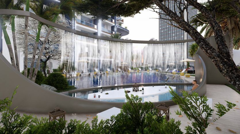 Une piscine extérieure luxueuse avec des jeux d'eau élégants et une végétation luxuriante, entourée des immeubles modernes de grande hauteur du Samana Waves Dubai, sous un ciel dégagé. Le bord de la piscine est équipé de chaises longues et animé