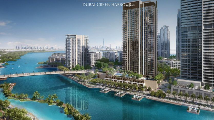 Vue aérienne du port de Dubai Creek présentant des immeubles de grande hauteur à côté d'un front de mer bleu vif, avec des palmiers, des bateaux et un horizon de ville lointain, présentant une opportunité idéale pour ceux qui cherchent à investir