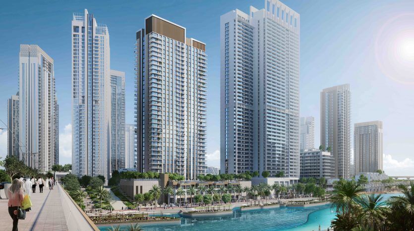 Une scène urbaine dynamique au bord de l'eau à Dubaï avec plusieurs immeubles de grande hauteur, une promenade animée avec des piétons et une grande piscine regorgeant de monde sous un ciel clair et ensoleillé.