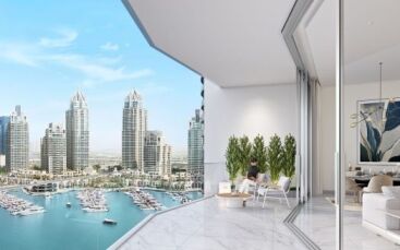 A person sits at a balcony table in a modern apartment in Dubai, overlooking a bustling cityscape with skyscrapers and a marina full of boats. The interiors and balconies blend harmoniously, bathed in the sunlight.