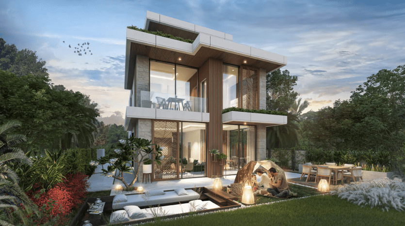 Une villa moderne de deux étages à Dubaï avec de grandes fenêtres éclairées au crépuscule et des panneaux extérieurs en bois. Devant, un couple profite d'un feu de joie confortable sur une pelouse entourée de sièges moelleux et de verdure.
