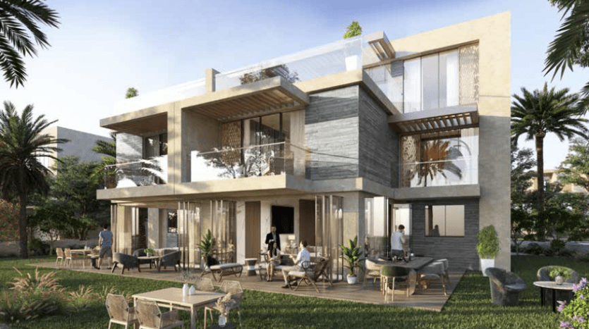 Une maison moderne de deux étages à Dubaï avec de vastes balcons, de grandes fenêtres en verre et des finitions extérieures en bois et en pierre. On voit des gens se détendre sur des meubles de patio dans un jardin luxuriant.
