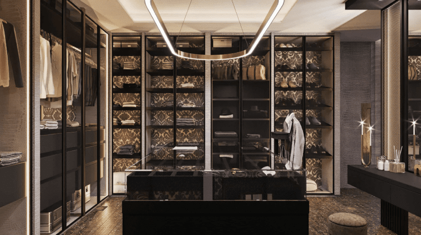 Un dressing luxueux dans une villa de Dubaï, doté d'étagères en bois sombre remplies de vêtements et d'accessoires soigneusement organisés, complétées par un grand luminaire circulaire et une vanité en miroir.