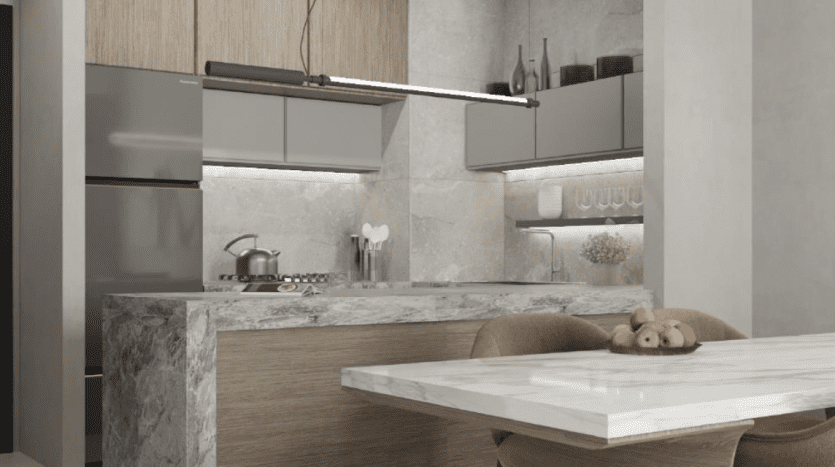 Intérieur de cuisine moderne dans un appartement de Dubaï comprenant un comptoir en marbre, des armoires en bois et des appareils électroménagers en acier inoxydable. Un bol de fruits est posé sur le comptoir.