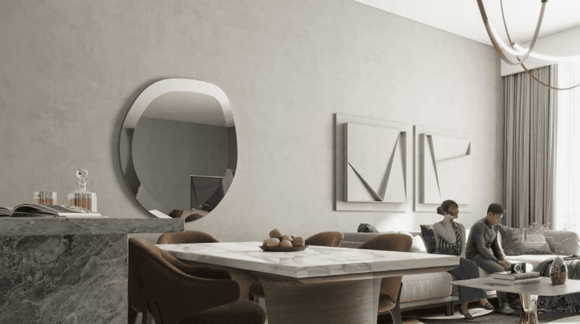 Un salon moderne dans une villa de Dubaï avec un couple assis sur un canapé, un miroir rond au mur, des meubles élégants dont une table à manger et un éclairage d'ambiance.