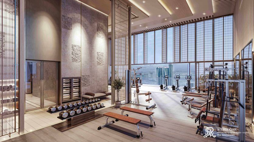 A spacious, modern gym with picture windows offering panoramic views of the city, perfect for investing in Dubai. The gym includes a variety of exercise equipment such as treadmills, weights and benches, in addition to