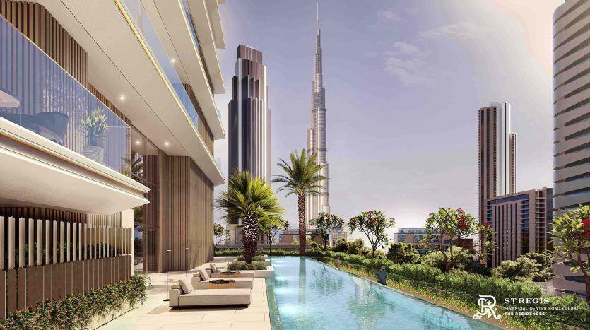 Luxurious rooftop pool on a sunny day with sun loungers and the rooftops of the city of Dubai in the background, with modern high-rise buildings and a clear blue sky.