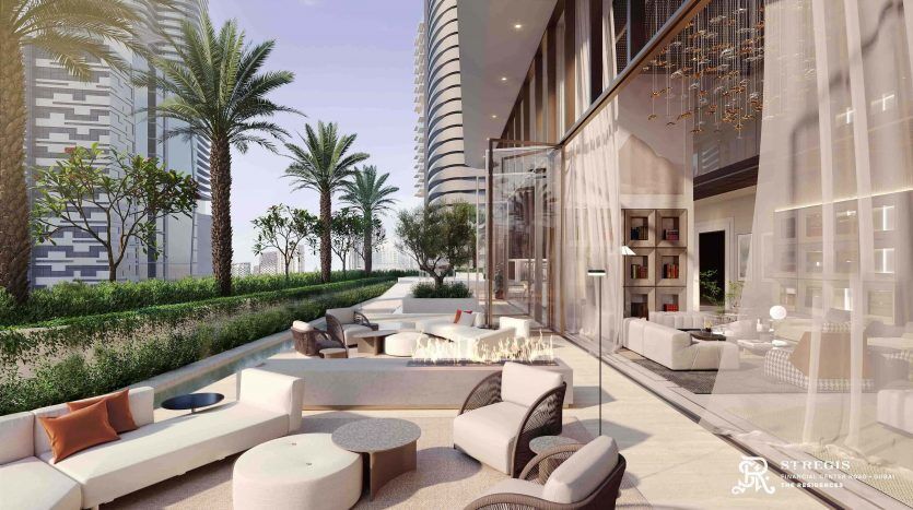 A luxurious outdoor lounge with plush seating and a fireplace, surrounded by lush palm trees and modern high-rise buildings in Dubai, reflecting a serene and opulent setting.