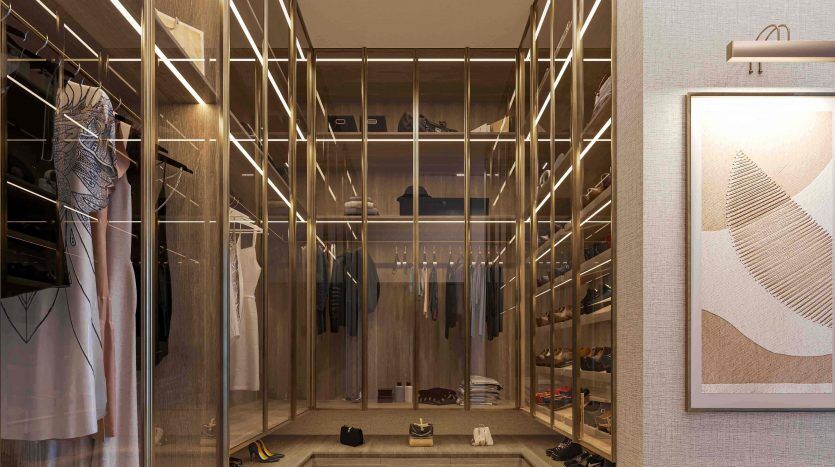 A luxurious dressing room in a Dubai villa, featuring an elegant glass and wood design with built-in shelves that carefully display clothes, shoes and accessories, all complemented by soft, tasteful lighting.