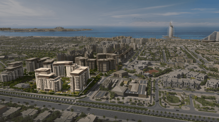 Aerial view of a coastal city with modern buildings and the distinctive sail-shaped Burj Al Arab skyscraper in Dubai. Developed urban area with green spaces and a neat layout, facing an ocean.