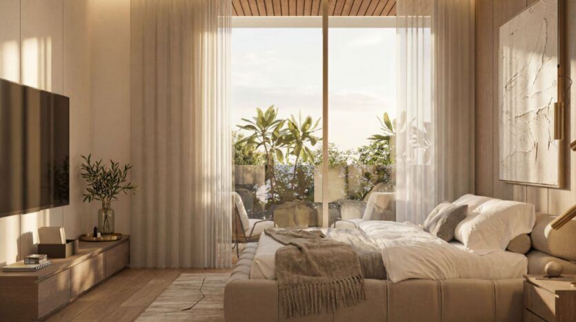 Cette chambre confortable et moderne du Lunaya Terraces est équipée d'un grand lit, d'une télévision, de meubles en bois et décorée dans des tons neutres. Des rideaux vaporeux habillent les portes vitrées donnant sur un balcon agrémenté de plantes, laissant entrer la lumière naturelle. Une couverture moelleuse est posée sur le lit.
