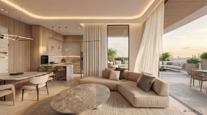 Un espace de vie moderne et ouvert à Lunaya Terraces, aux tons neutres, agrémenté d'un canapé beige aux lignes courbes, d'une table basse en marbre, d'un coin repas et d'une cuisine épurée. De grandes baies vitrées s'ouvrent sur une terrasse offrant une vue imprenable sur la ville au coucher du soleil.