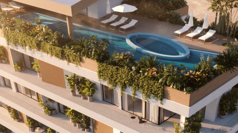 Vue depuis le toit des « Lunaya Terraces », un immeuble moderne doté d'une longue piscine agrémentée d'un coin salon circulaire, entourée de transats, de parasols et d'une végétation luxuriante sur la terrasse.
