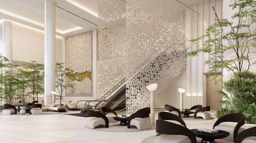 Hall d'hôtel moderne situé dans le quartier O1NE, avec des cloisons sculpturales, des plantes vertes, des fauteuils en noir et blanc, des tables rondes et un escalator menant à l'étage supérieur. La lumière naturelle crée une atmosphère lumineuse et aérée.