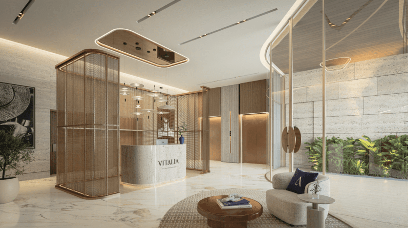 Hall d'accueil luxueux et moderne avec sol en marbre, réception avec le logo « Vitalia » et éclairage élégant. Coin salon contemporain avec de grands panneaux de verre offrant une vue sur la végétation luxuriante à l'extérieur. Situé sur Palm Jumeirah, il présente des tons chauds et terreux dans toute la décoration.