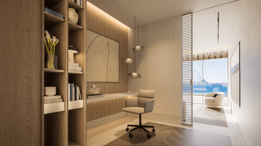 Un bureau moderne avec des étagères en bois, un bureau et une chaise de bureau. Une grande baie vitrée s'ouvre sur un balcon avec vue sur la mer du Vitalia Palm Jumeirah. Les tons neutres créent une atmosphère calme, avec des œuvres d'art murales abstraites et une plante en pot ajoutant une touche décorative.