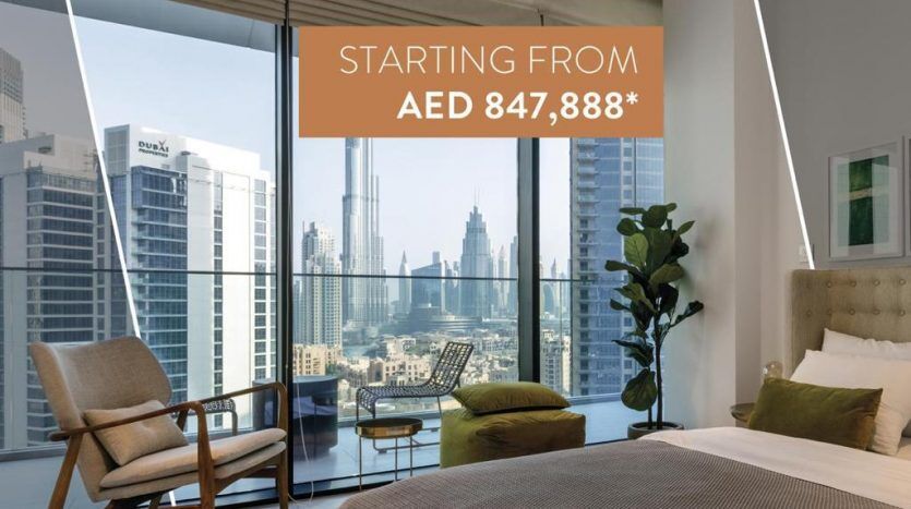Un intérieur d'appartement moderne comprenant une chambre avec un grand lit, une chaise et une fenêtre donnant sur les toits de la ville. La superposition de texte présente une offre de prix de départ pour la propriété Marquise Square Dubai.