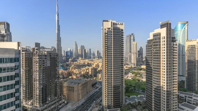 Une vue panoramique du centre-ville de Dubaï, notamment de la place Marquise, des gratte-ciel comme le Burj Khalifa, du ciel bleu clair et des routes urbaines.