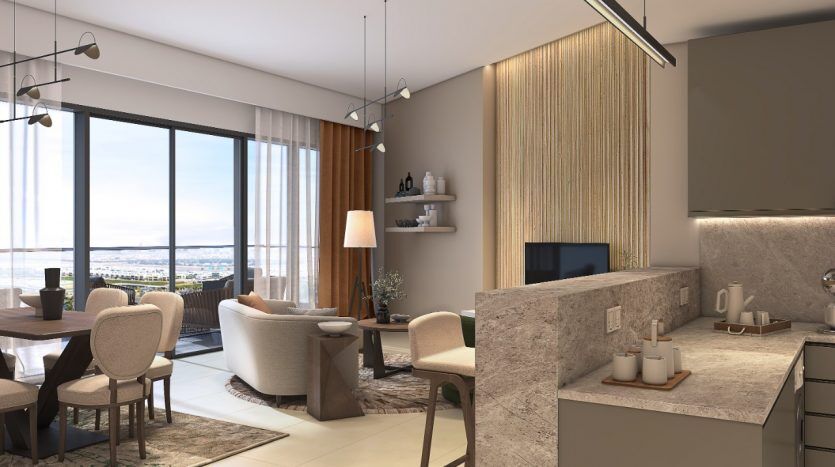 Intérieur d'appartement moderne comprenant une cuisine ouverte avec des comptoirs en marbre relié à un salon confortable avec des sièges moelleux et de grandes fenêtres offrant une vue panoramique sur Dubaï.