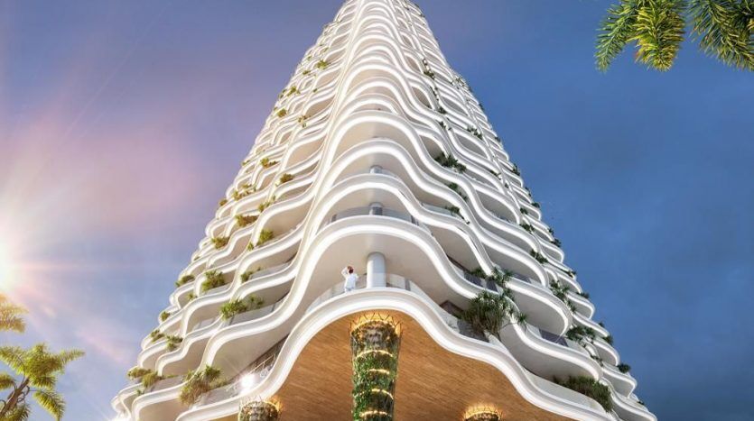 Villa futuriste de grande hauteur à Dubaï avec des balcons blancs ondulés ornés de verdure luxuriante, sous un ciel clair au coucher du soleil. Une personne est visible sur l'un des balcons inférieurs.