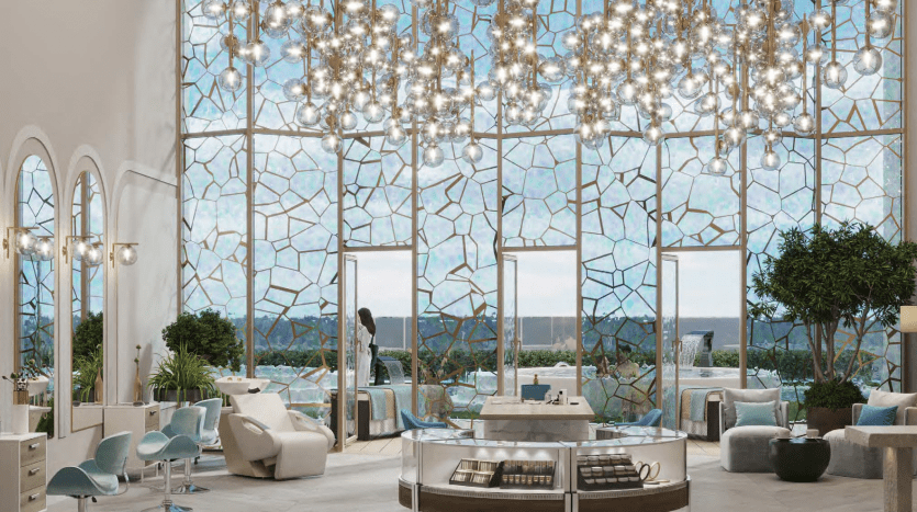 Un intérieur élégant d'un spa ou d'un salon haut de gamme à Dubaï avec de grands vitraux, des lustres modernes, des sièges élégants et deux personnes debout près de grandes fenêtres.