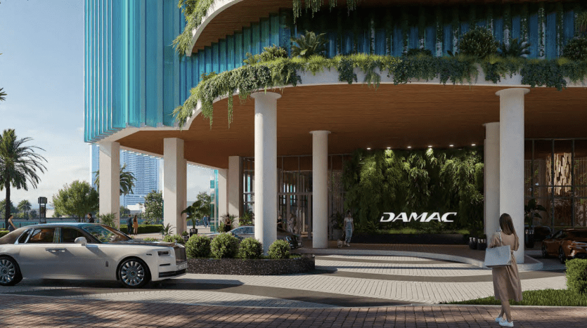 Entrée d'hôtel luxueuse à Dubaï avec une conception architecturale moderne, une verdure luxuriante, une Rolls-Royce garée devant et une personne prenant une photo.