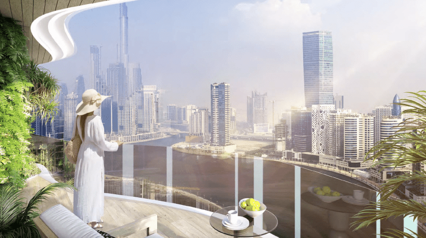 Une femme vêtue d'une robe blanche et d'un chapeau se tient sur le balcon moderne d'un appartement de Dubaï, regardant un paysage urbain ensoleillé avec des gratte-ciel et une verdure verdoyante.