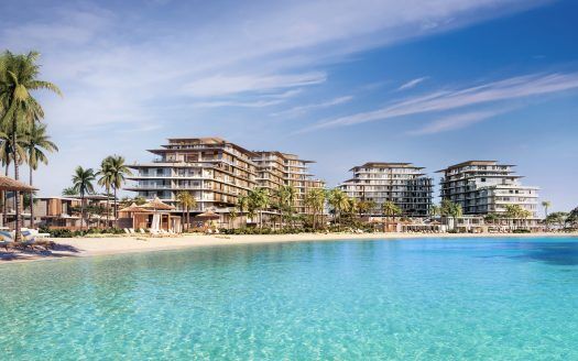 Complexe luxueux en bord de mer avec des bâtiments modernes à plusieurs étages, entouré de palmiers luxuriants, surplombant une grande piscine bleue sereine sous un ciel dégagé, idéal comme investissement immobilier à Dubaï.