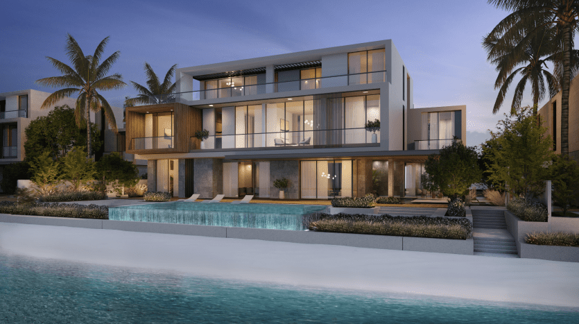 Modern beachfront villa in Dubai with light-filled interiors featuring large glass windows, several balconies and surrounded by palm trees and landscaped gardens at dusk.