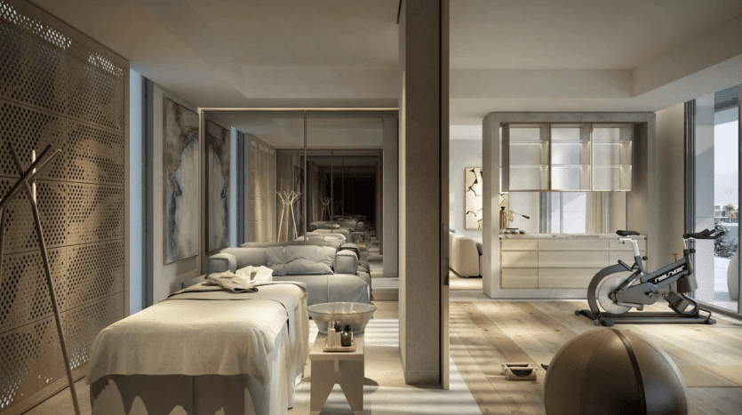 A modern luxury apartment interior in Dubai with an open layout connecting a bedroom, living room and sports area, showcasing contemporary furnishings and natural light.