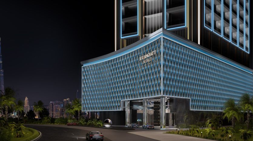 Night view of a modern, illuminated villa in Dubai with geometric facade patterns, a prominent entrance and lush surrounding greenery. A car approaches the building.