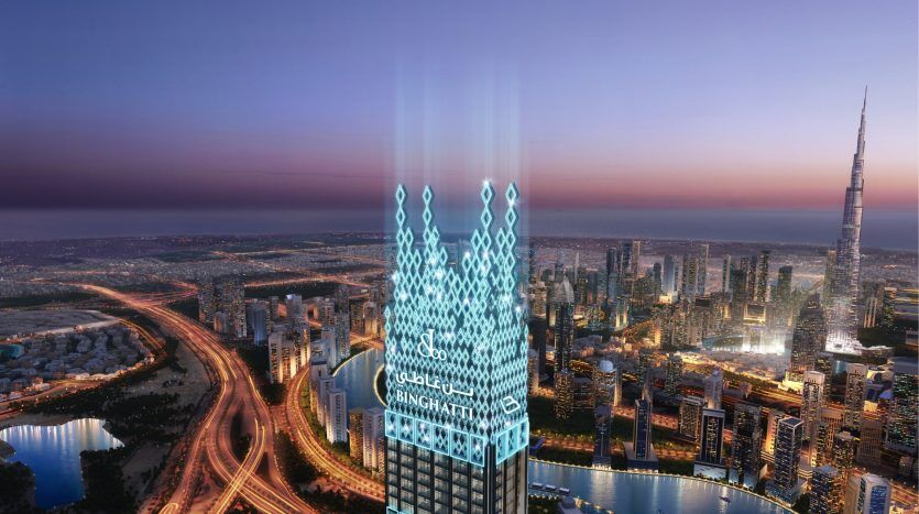 A futuristic building in a twilight cityscape in Dubai, featuring vibrant blue light and Arabic script, with neighboring skyscrapers and winding roads below.