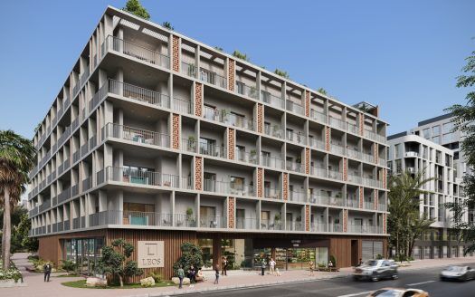 Un immeuble d'appartements moderne à Dubaï avec plusieurs balcons, de grandes fenêtres et des espaces commerciaux au rez-de-chaussée, entouré d'une verdure luxuriante et de rues fréquentées par des voitures et des piétons.