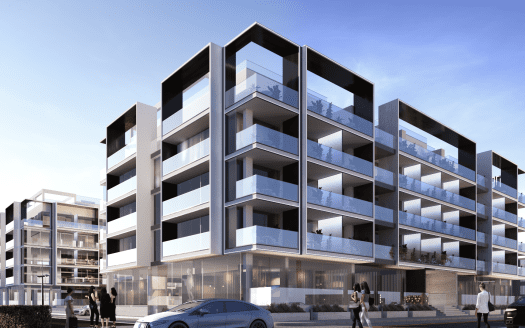 Immeubles d'appartements modernes à plusieurs étages avec de vastes balcons en verre sous un ciel clair à Dubaï. Les gens marchent et une voiture est garée devant.