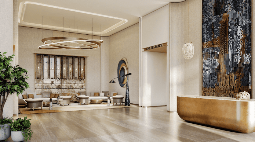 Le hall de One Residences présente un grand lustre élégant, un coin salon luxueux, des œuvres d'art murales abstraites et un élégant bureau de réception doré. La lumière naturelle afflue, mettant en valeur la palette de couleurs neutres et le décor contemporain. Les plantes en pot ajoutent une touche de verdure.