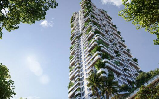 Un grand gratte-ciel moderne, Talea by Beyond, avec des balcons blancs ornés de plantes et d'arbres verdoyants, vus d'en bas sur fond de ciel bleu et encadrés par des branches feuillues.