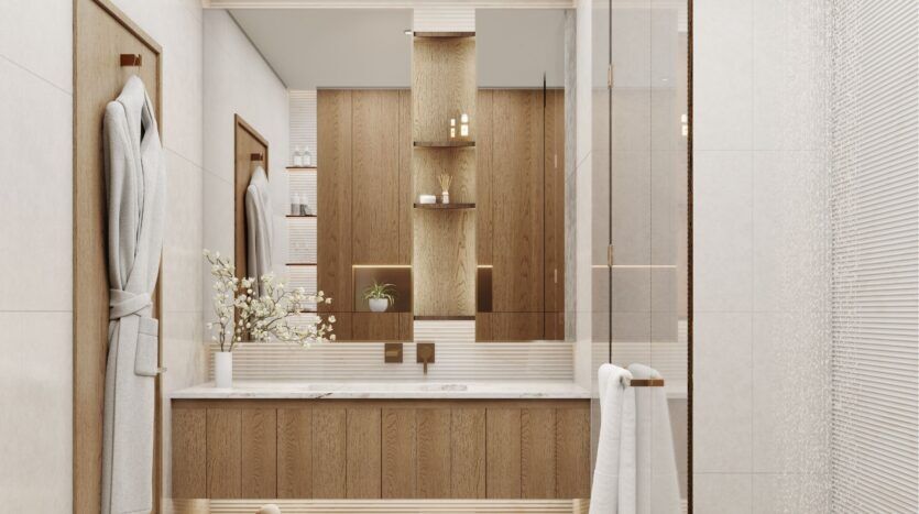 Salle de bains moderne à Wynwood Horizon de Imtiaz avec des accents en bois, un grand miroir, un comptoir avec une plante et des articles de toilette, des peignoirs blancs sur la porte, et des étagères ouvertes présentant des objets de façon ordonnée. Un design neutre, lumineux et épuré.