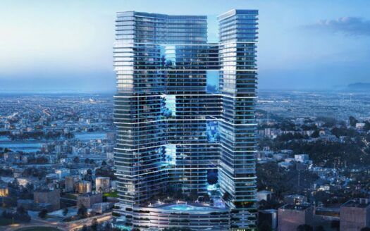 Un immeuble moderne aux façades de verre et aux multiples terrasses surplombe un paysage urbain tentaculaire au crépuscule, alors que les lumières commencent à apparaître dans la ville en contrebas.