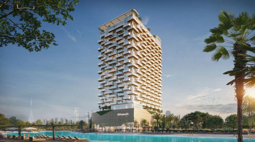 Le Caden est un hôtel moderne de grande hauteur avec un balcon au design géométrique unique, situé à côté d'une grande piscine entourée de palmiers et de chaises longues, le tout sous un ciel bleu clair avec la ligne d'horizon de la ville en arrière-plan.