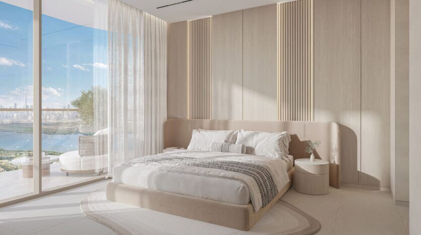 Chambre à coucher moderne et minimaliste au Caden, avec un grand lit, des tons neutres, des panneaux muraux texturés, une table de nuit ronde avec une petite plante, des fenêtres allant du sol au plafond, des rideaux diaphanes et un balcon avec vue sur la ville et l'eau.
