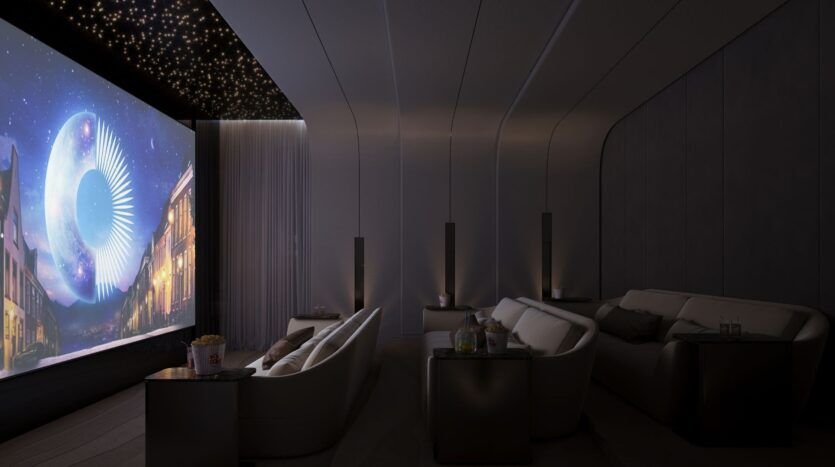Découvrez le Caden : un home cinéma luxueux doté de canapés en peluche, de tables d'appoint et d'un grand écran affichant une scène au clair de lune. Des lumières étoilées ornent le plafond, tandis que du pop-corn et des boissons attendent sur les tables pour votre plus grand plaisir.