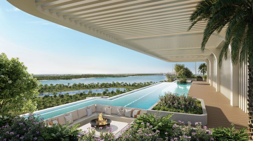 Découvrez la luxueuse piscine à débordement sur le toit du Caden, avec un coin salon en contrebas autour d'un foyer, entourée de plantes luxuriantes et surplombant la rivière et la verdure sous un ciel bleu limpide.