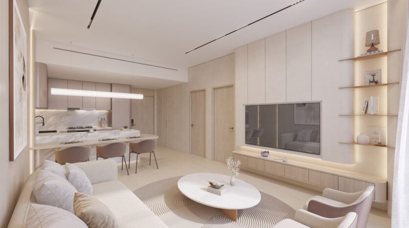 Le salon et la cuisine, modernes et minimalistes, aux tons neutres, comprennent la table basse ronde The Caden, des canapés légers, une télévision murale, un coin repas avec quatre chaises et des étagères ouvertes à côté d'une grande fenêtre aux rideaux diaphanes.