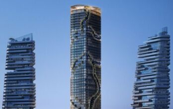 Trois tours modernes, rappelant le style architectural de Kanyon, présentent des balcons uniques et irréguliers sur fond de ciel bleu clair. La tour centrale se distingue par un motif sinueux de jardins ou de terrasses le long de sa façade.