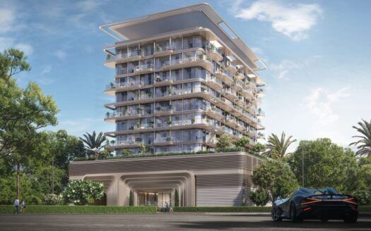 Un bâtiment moderne de plusieurs étages avec de grands balcons et de la verdure est entouré d'arbres et de palmiers. Au premier plan, une voiture de sport élégante est garée sous un ciel bleu clair, reflétant le luxe de The Tides by Amis.