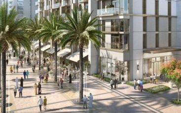 Une scène de rue urbaine animée avec des gens marchant parmi des bâtiments et des magasins modernes, bordés de grands palmiers et de plantes décoratives sous un ciel dégagé, surplombant la couronne du Burj.
